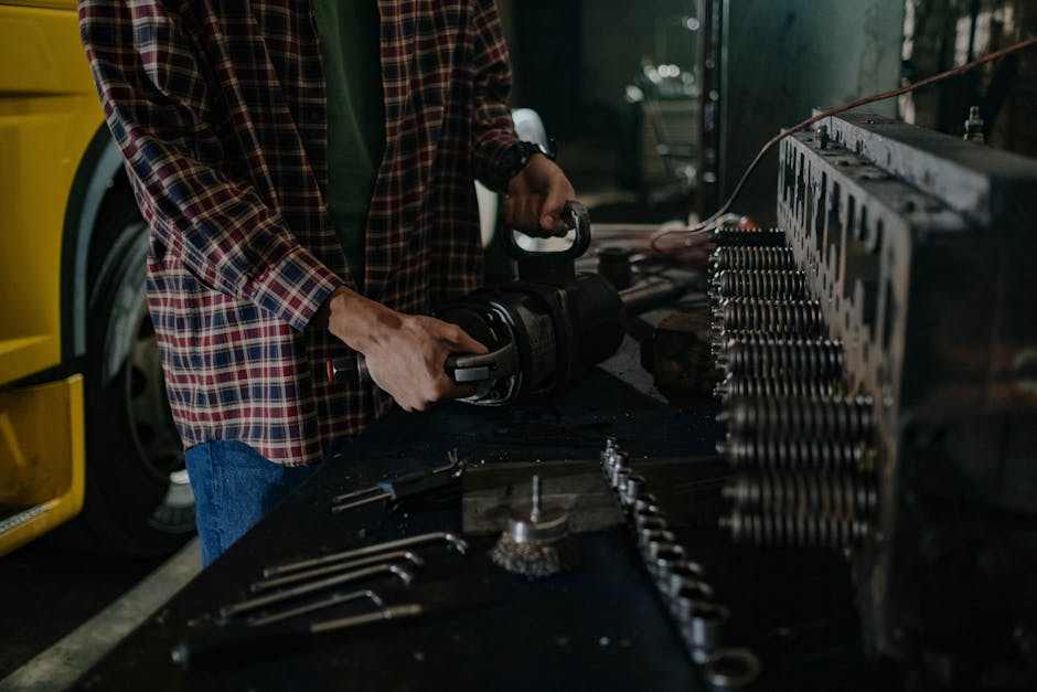 Mechanic using tools in an auto repair workshop for vehicle maintenance.